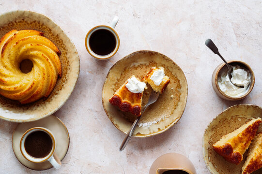 Stack of golden bundt cake with coffee and cream