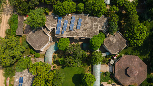 Lahore, Punjab, Pakistan - 08 September 2026: Aerial view of the government office building data canter featuring rooftop solar panels surrounded by lush green trees.