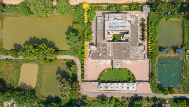 Lahore, Pakistan - 08 September 2026: Aerial view of a large government building data canter complex featuring solar panels on the roof, surrounded by multiple ponds, manicured lawns, and lush trees.