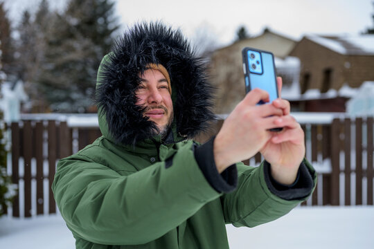 Man take selfie outdoors in winter snow with smartphone
