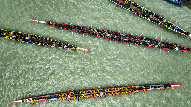 Baghabari, Rajshahi Division, Bangladesh - 20 August 2022: Aerial view of long racing boats filled with rowers competing on the river, showcasing synchronized paddling.