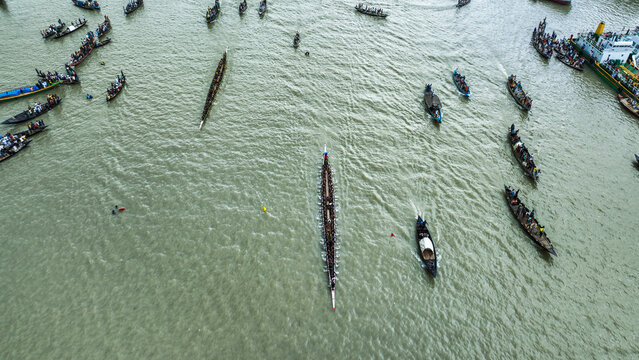 Baghabari, Bangladesh - 20 August 2022: Aerial view of traditional long boats racing on the river with many spectators in smaller boats.