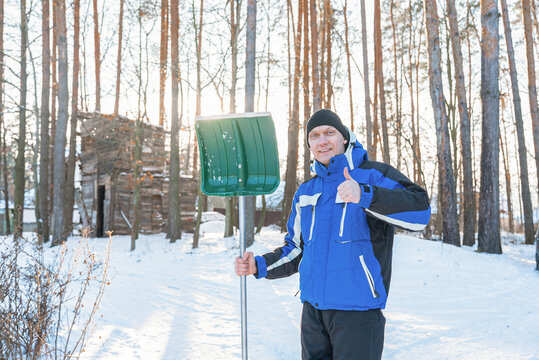 Portrait of man with snow shovel during winter yard chores