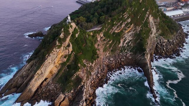 Aerial revealing view of Getaria lighthouse on rocky coastline
