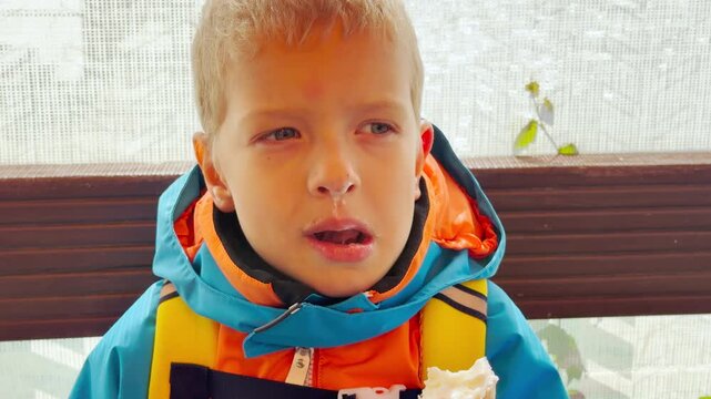 A cute boy eats ice cream on Valaam, Lake Ladoga. This sweet moment evokes a happy, joyful, and heartwarming feeling.