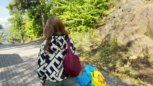 A woman and child walk along a stone path on Valaam, Lake Ladoga. This joyful journey evokes a happy, warm, and peaceful feeling.