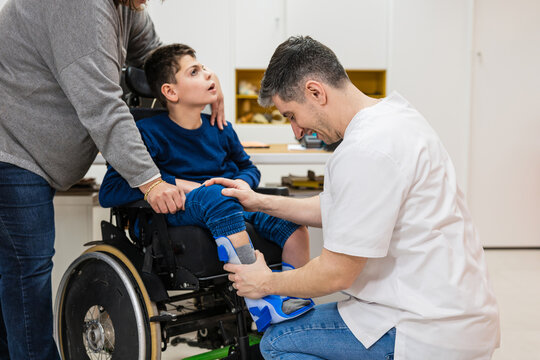 Orthopedic technician fitting brace on childs leg