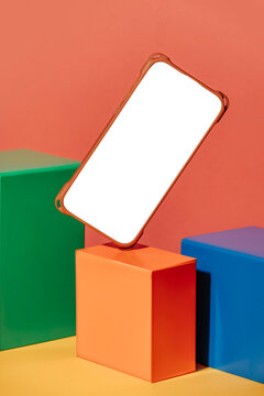 Floating smartphone with blank screen above colorful cubes