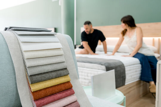 Couple choosing mattress in furniture store showroom