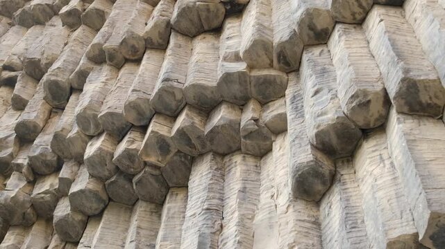 Symphony of Stones, Armenia. Textured stone wall features hexagonal columns displaying unique natural patterns and formations in a rocky landscape environment