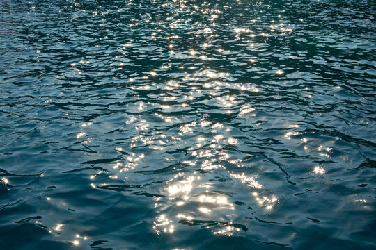 Sunlight sparkle on rippling blue ocean water surface