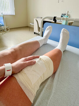 Patient with bandaged knee resting in hospital bed