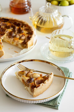 Slice of delicious fruit tart with figs and peaches served with herbal tea and honey