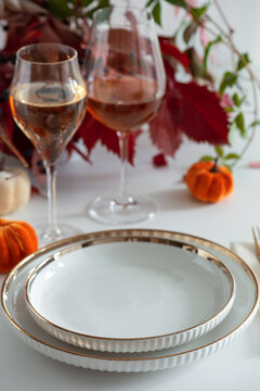 Elegant Autumn Table Setting with Wine Glasses and Decorative Pumpkins