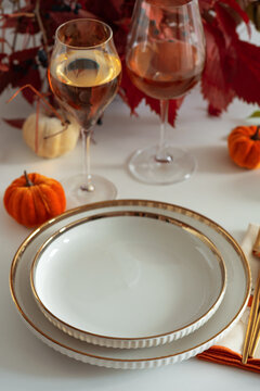 Elegant Thanksgiving Table Setting with Pumpkins Wine Glasses and Gold Trimmed Plates