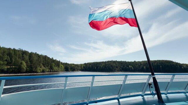 The Russian flag waves proudly on a ship deck. It overlooks a peaceful lake and green forest. This sunny view inspires a calm, patriotic feeling of freedom and joyful adventure.