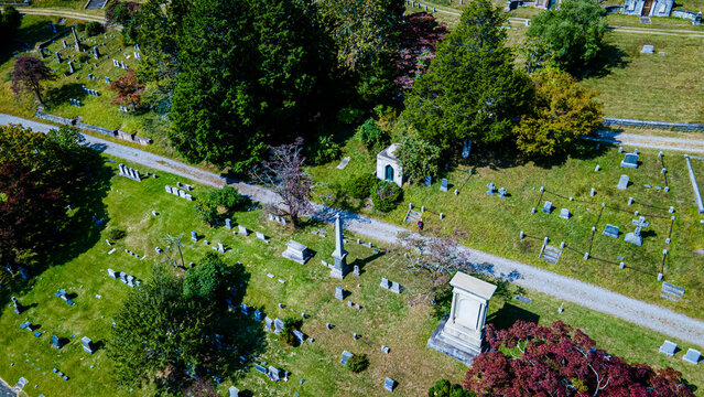 Sleepy Hollow, United States - 22 September 2020: Aerial view of Sleepy Hollow Cemetery featuring historic gravestones, monuments, and lush green trees under a clear sky.