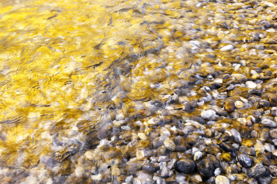 Golden sea water over pebble beach at Helgoland dune