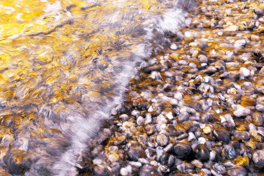 Golden sea foam over rocks at Helgoland dune beach