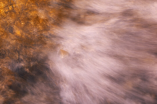 Golden wave patterns on Helgoland Dune beach at sunset