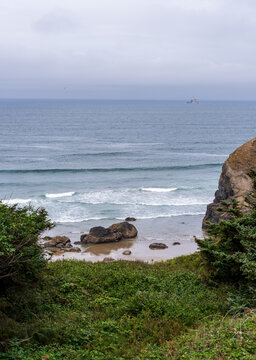 Tillamook Rock Lighthouse stands offshore in the Pacific Ocean viewed from the coastal bluffs of Ecola State Park in Clatsop County Oregon.