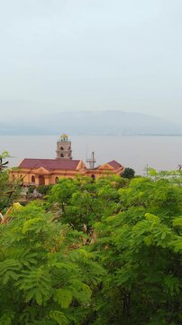 Phuoc Mai Lighthouse in Quy Nhon, Vietnam. Historic landmark on coastal peninsula with lush green grounds, scenic ocean views, surrounding mountains, and tropical nature.