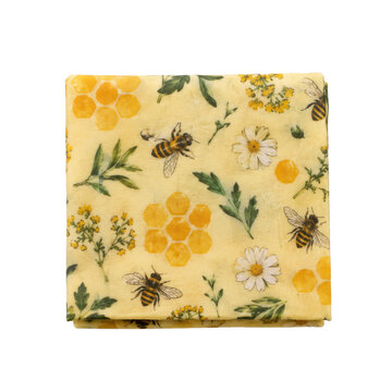 Folded yellow beeswax food wrap with a vibrant pattern of bees, honeycombs, and flowers on a white background