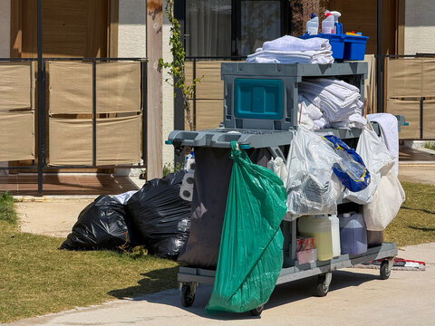 Hotel housekeeping cart with linen and waste bags outdoors
