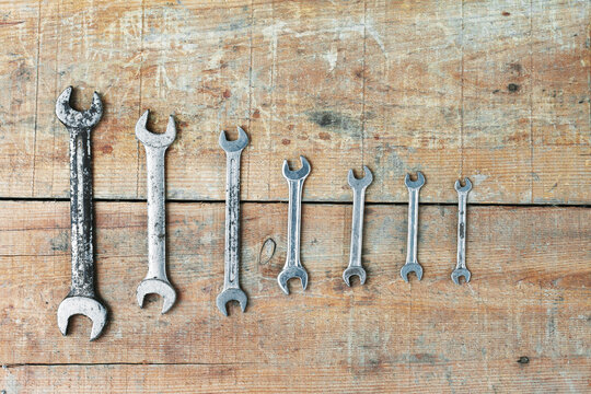 Worn wrench set on rustic wooden workbench background