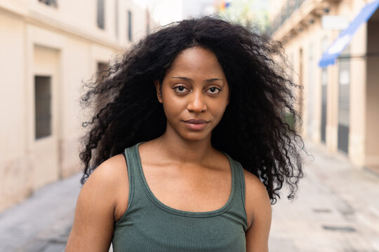 Confident woman with curly hair on a city street