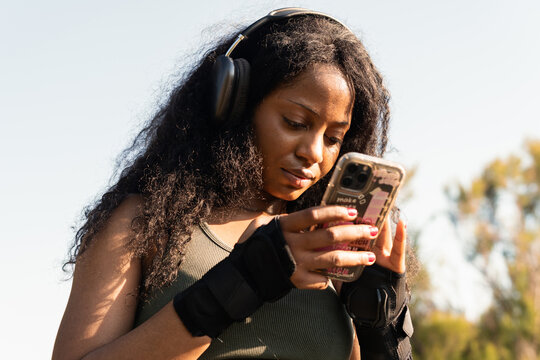 Woman listen to music and use smartphone outdoors