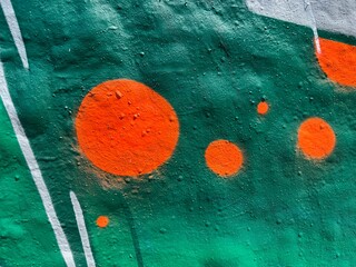 Urban street art close up with orange dots on teal and green background © LilliM