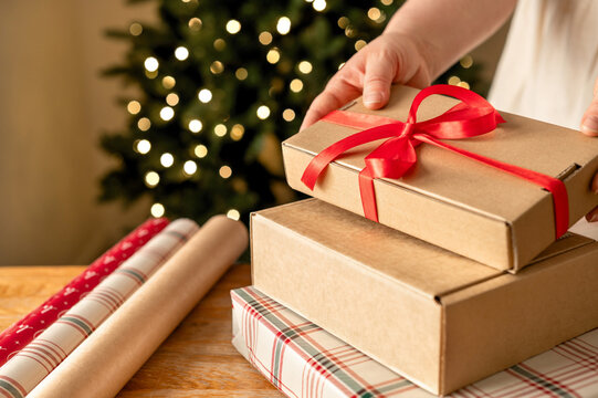 Hand tie ribbon on stacked Christmas gift boxes