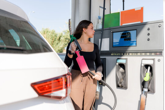 Woman refueling car at modern gas station