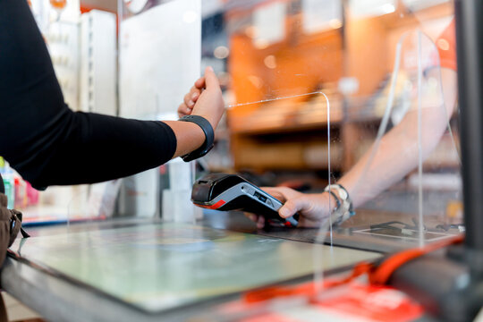 Contactless watch payment at gas station checkout counter