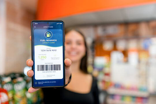 Woman show fuel rewards loyalty card on smartphone