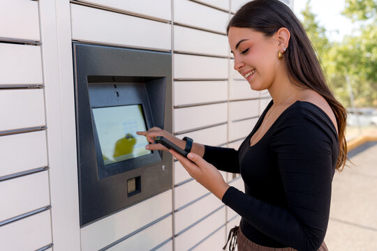 Woman send package through smart parcel locker with smartphone