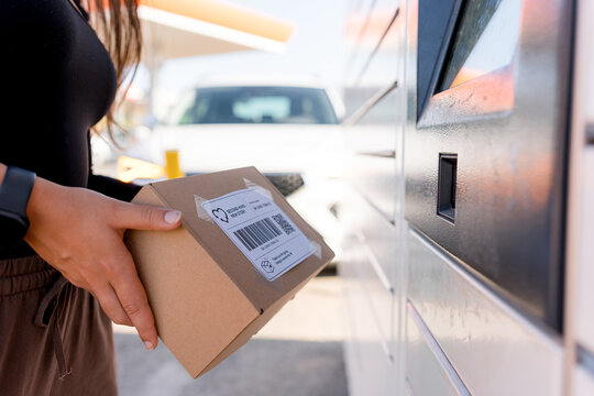 Woman send package through automated parcel locker
