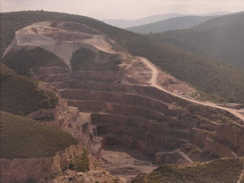 Toliman Municipality, Mexico - 19 September 2026: Aerial view of Caleras de Bernal quarry, showing terraced rock formations, dirt access roads, and hilly landscape.