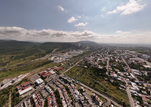 Santiago de Queretaro, Mexico - 18 September 2026: Aerial view of Privalia Ambienta residential development surrounded by rolling hills, urban infrastructure, and green landscapes.