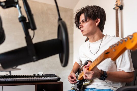 Young musician record electric guitar in home studio