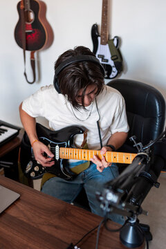 Music compositor play electric guitar in home studio