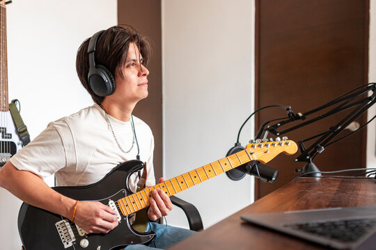 Music composer recording electric guitar in home studio