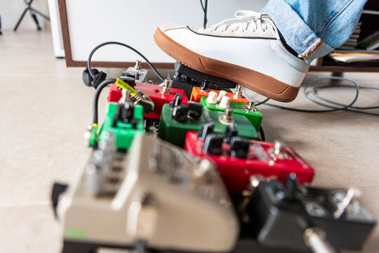 Musician using guitar effect pedalboard in studio