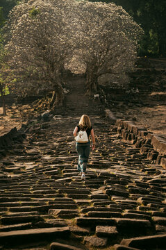 Traveler walking ancient stone path at Wat Phu Champasak Laos