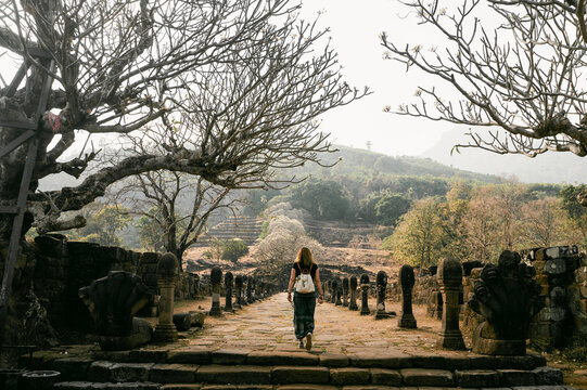 Traveler walks through ancient Wat Phu temple in Laos