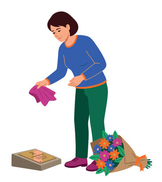 Woman cleaning memorial plaque with flowers nearby, demonstrating a touching moment of remembrance and tribute for a lost loved one, symbolizing grief and respect.