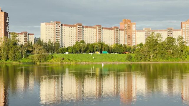 Buildings stand along the Neva River in Saint Petersburg, reflecting in the water. This scenic view inspires a calm, peaceful, and relaxing feeling.