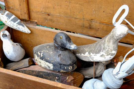 Antique weathered wooden bird decoys in rustic wooden crate