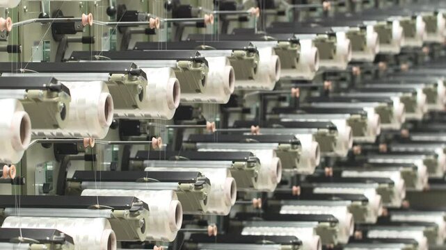 Industrial automation factory production line weaving plant of polypropylene yarn spools bags textile spinning machine in a modern nylon manufacture enterprise, white thread reels ropes plastic sacks